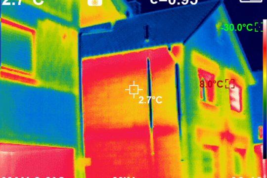 Foto: Thermografie Aufnahme eines Gebäudes in Erfelden. Über die rot eingefärbten Bereiche geht mehr Wärme verloren, hier insbesondere über die Fenster, die Rolladenkästen und die Deckenauflage. Foto: Stadt Riedstadt