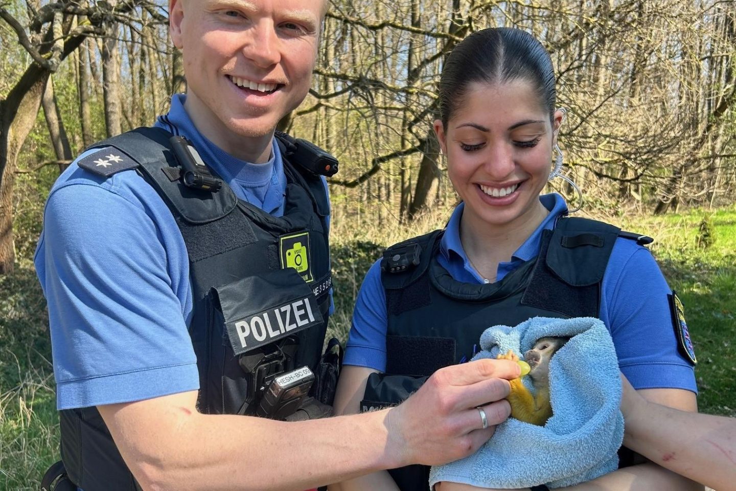 Totenkopfäffchen mit Polizeibeamtin und -beamten. Foto: Polizei Darmstadt